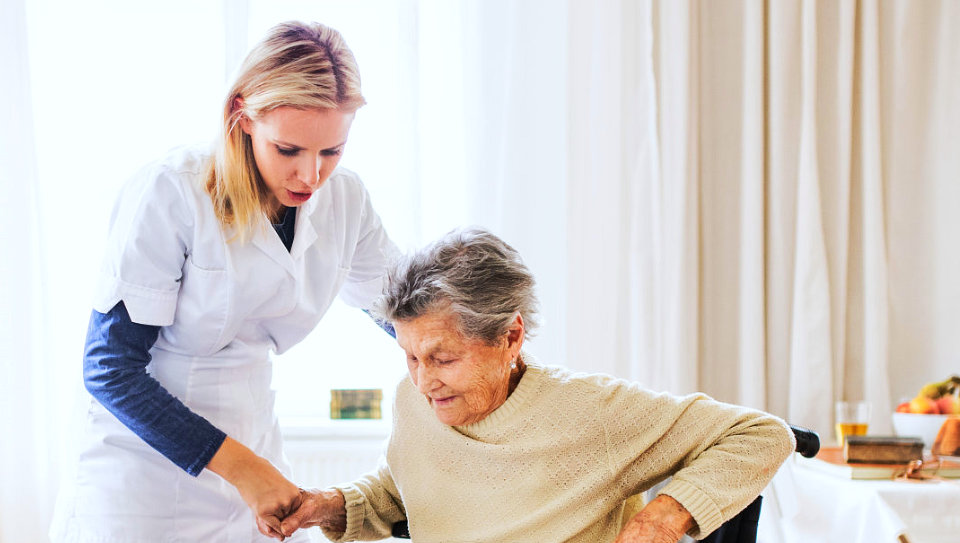 image of an adult woman assisting an elderly woman