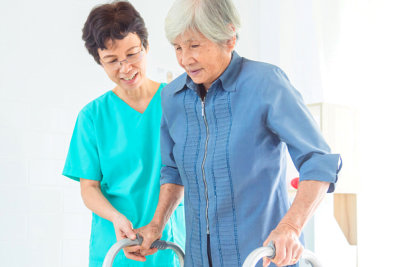 healthcare staff helping senior woman to walk