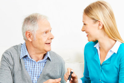 senior man eating his food accompanied by the healthcare staff