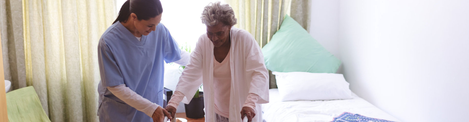 serior woman practice walking accompanied by the healthcare staff