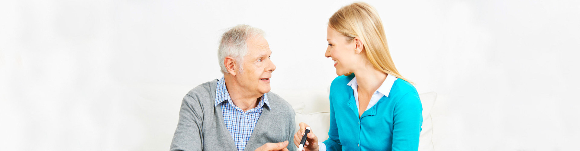 healthcare staff helping senior man to eat his breakfast